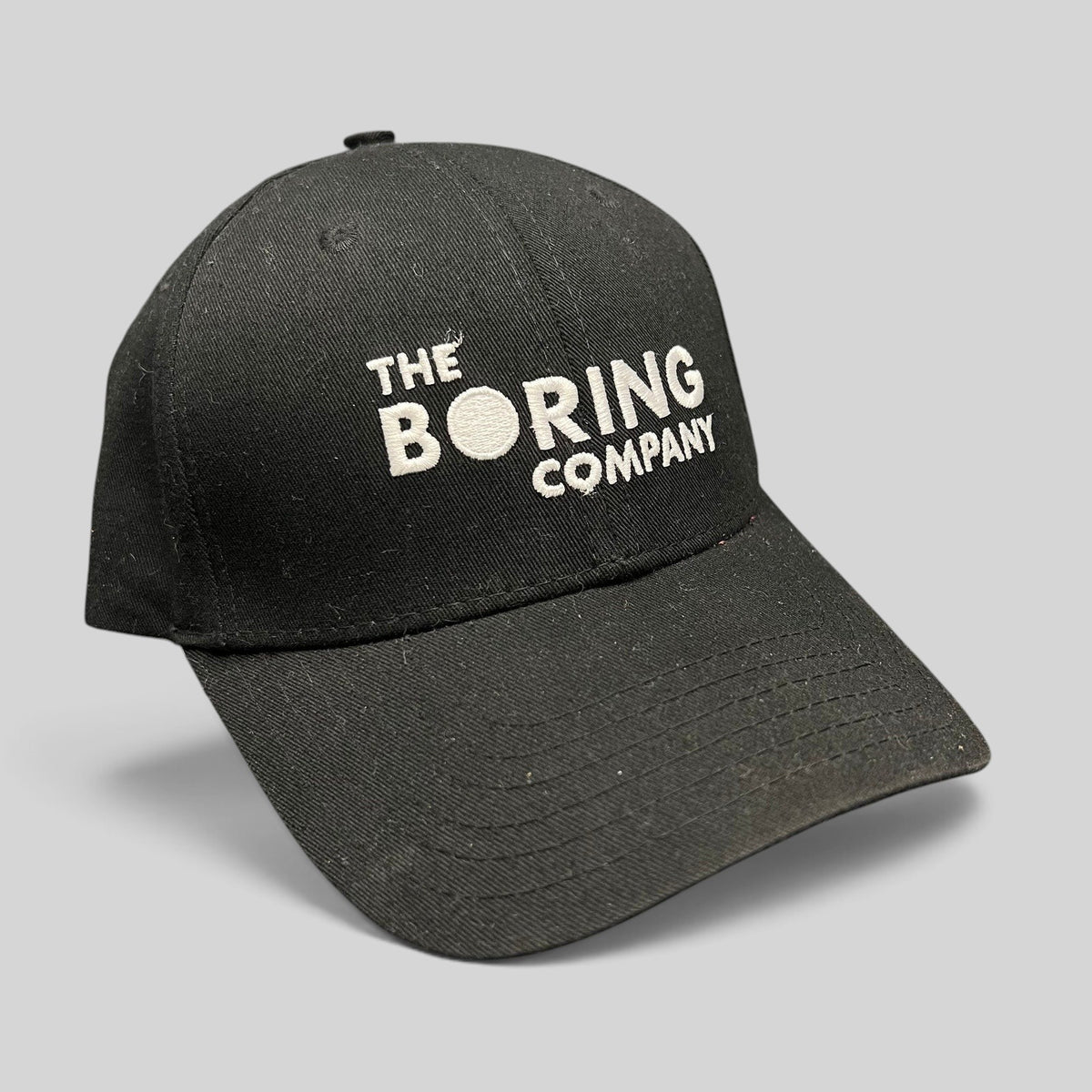 Raree Finds black The Boring Company strapback hat with white embroidered logo on a structured cotton crown