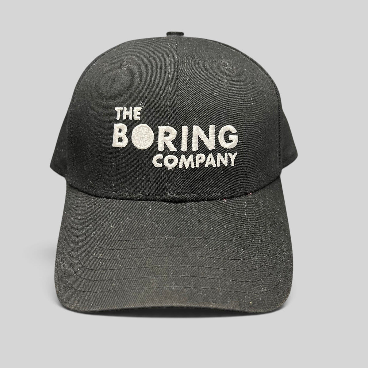 Raree Finds black The Boring Company strapback hat with white embroidered logo on the front