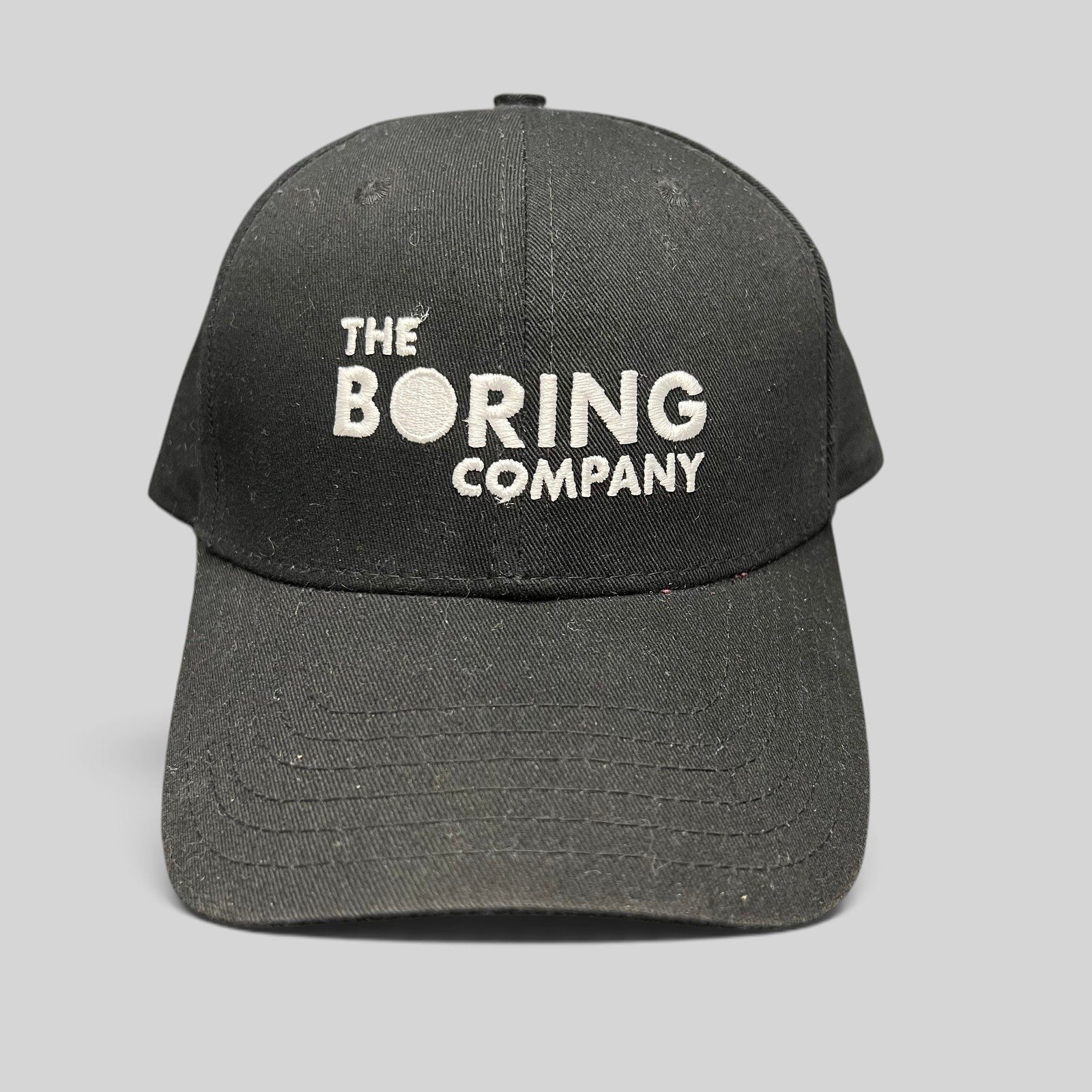 Raree Finds black The Boring Company strapback hat with white embroidered logo on the front