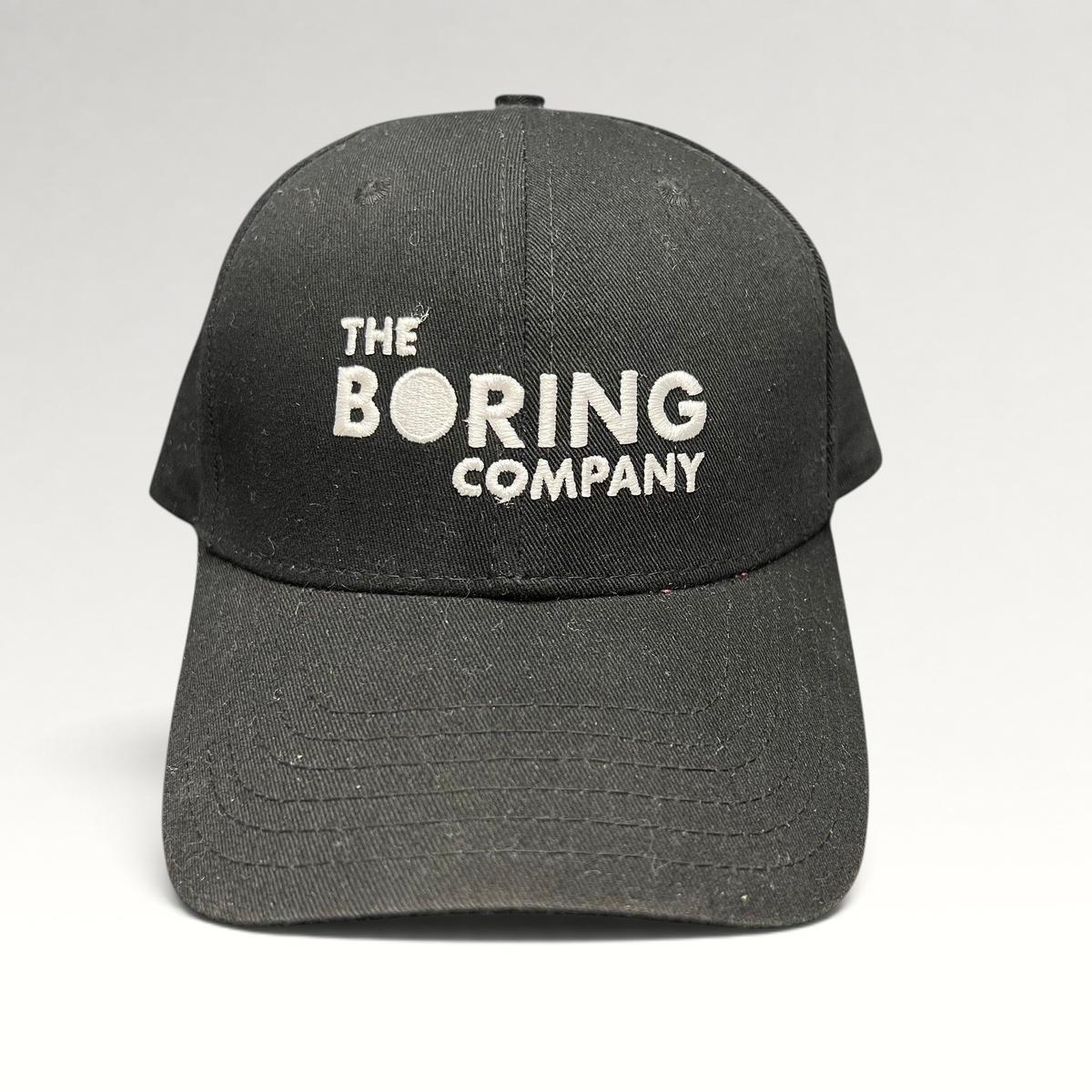 Raree Finds black The Boring Company strapback hat with white embroidered logo on the front