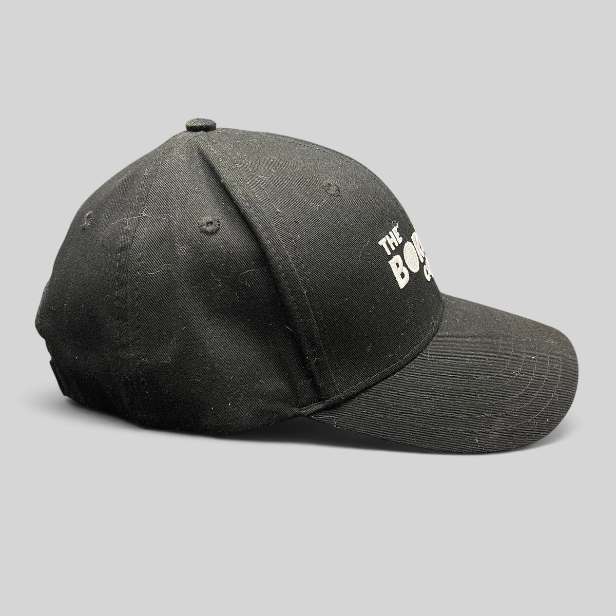 Raree Finds black The Boring Company strapback hat with white embroidered logo on a structured cotton crown