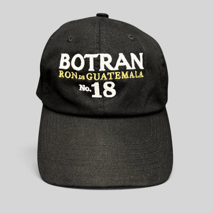 Raree Finds black cotton strapback hat featuring white and gold Botran Ron de Guatemala No. 18 embroidered logo