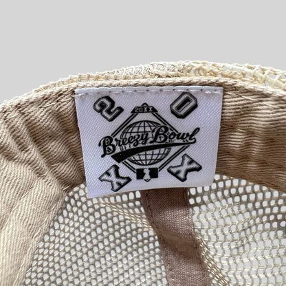 Raree Finds Breezy Bowl XX trucker hat interior label with globe logo and 20th anniversary branding on mesh fabric