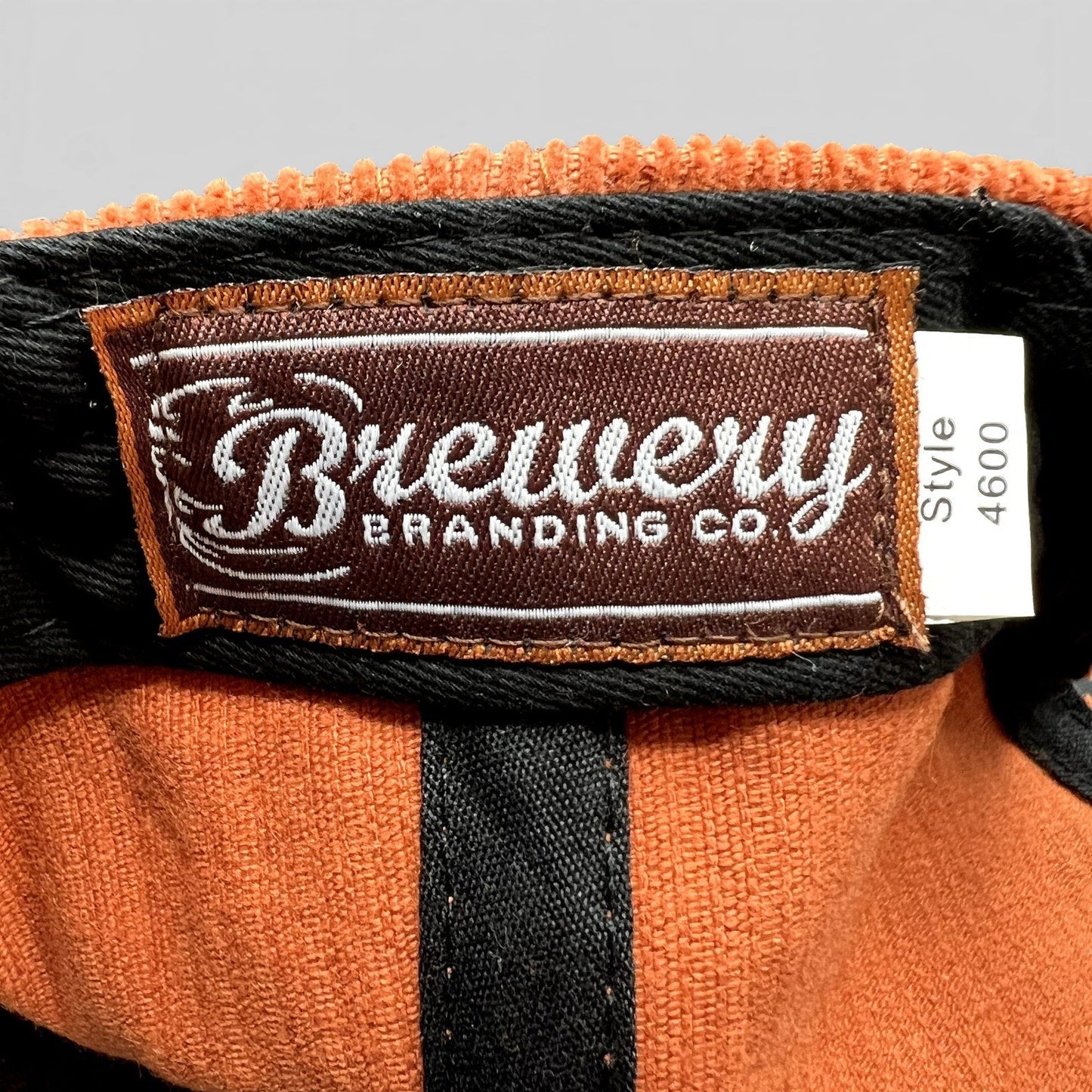Raree Finds Brewery Branding Co. interior label on a burnt orange corduroy snapback hat with style 4600 tag