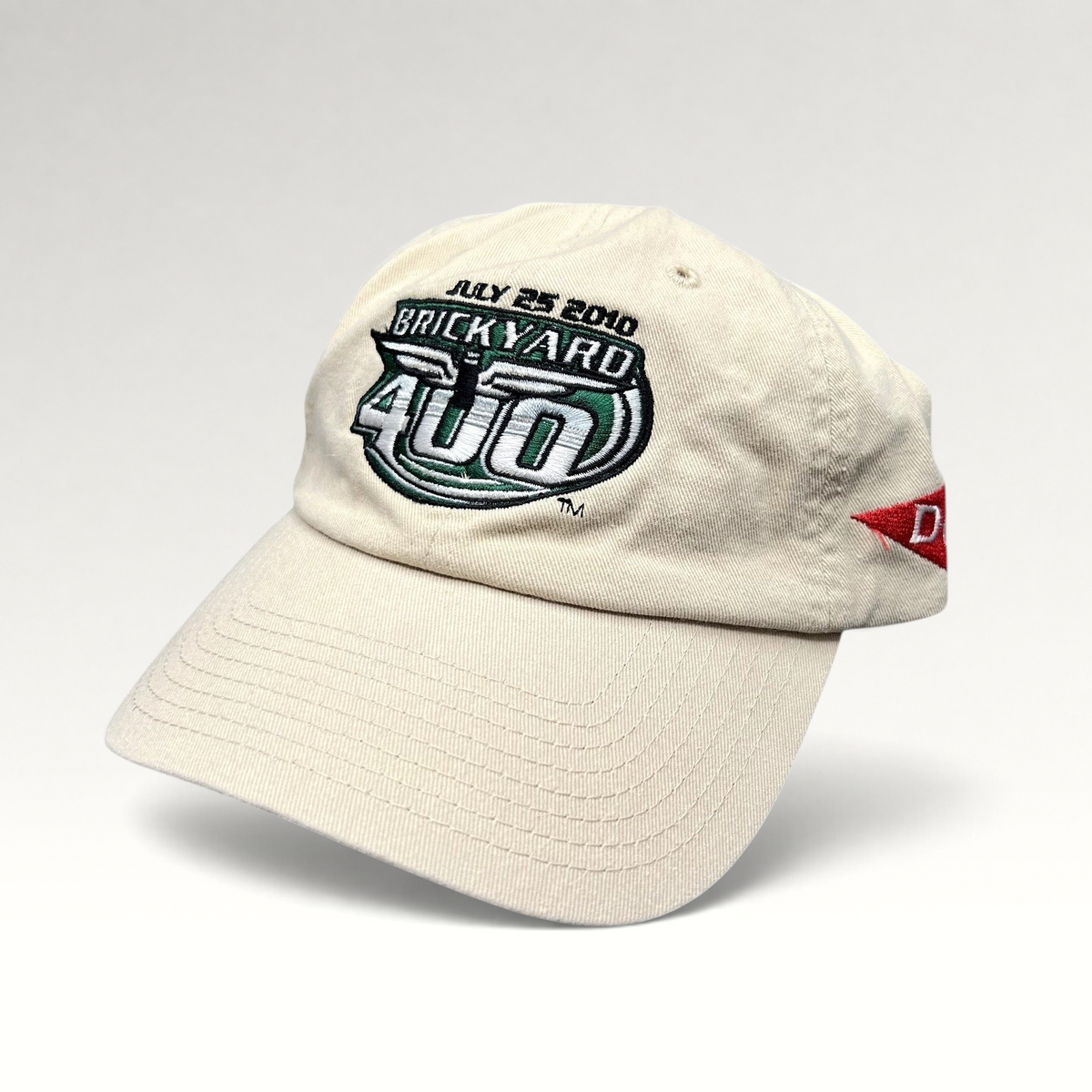 Raree Finds cream cotton 2010 Brickyard 400 NASCAR strapback hat with embroidered logo and Budweiser side detail.