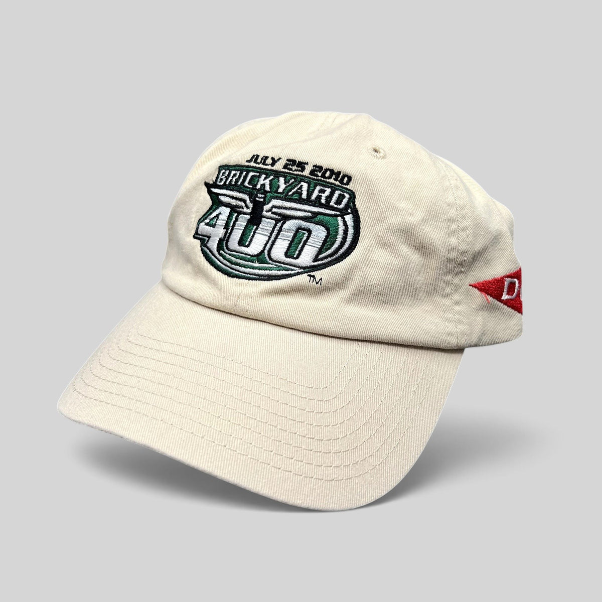 Raree Finds cream cotton 2010 Brickyard 400 NASCAR strapback hat with embroidered logo and Budweiser side detail.