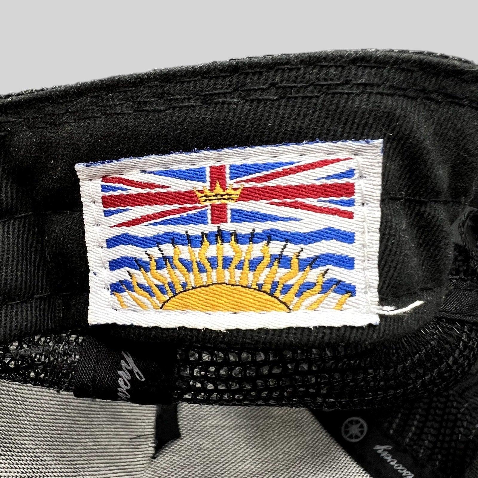 Raree Finds Discovery Collection trucker hat interior tag featuring a detailed embroidered British Columbia flag patch.