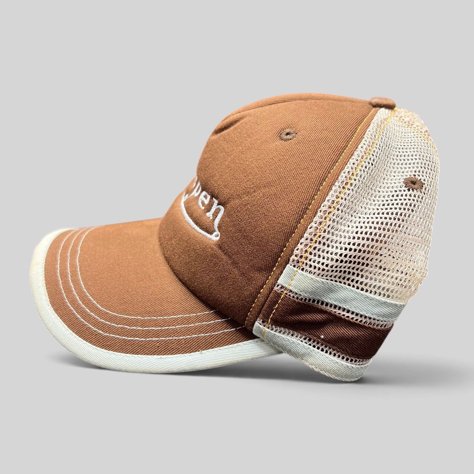 Raree Finds brown Aspen trucker hat with white mesh back, curved brim, and embroidered script in a 2000s style.