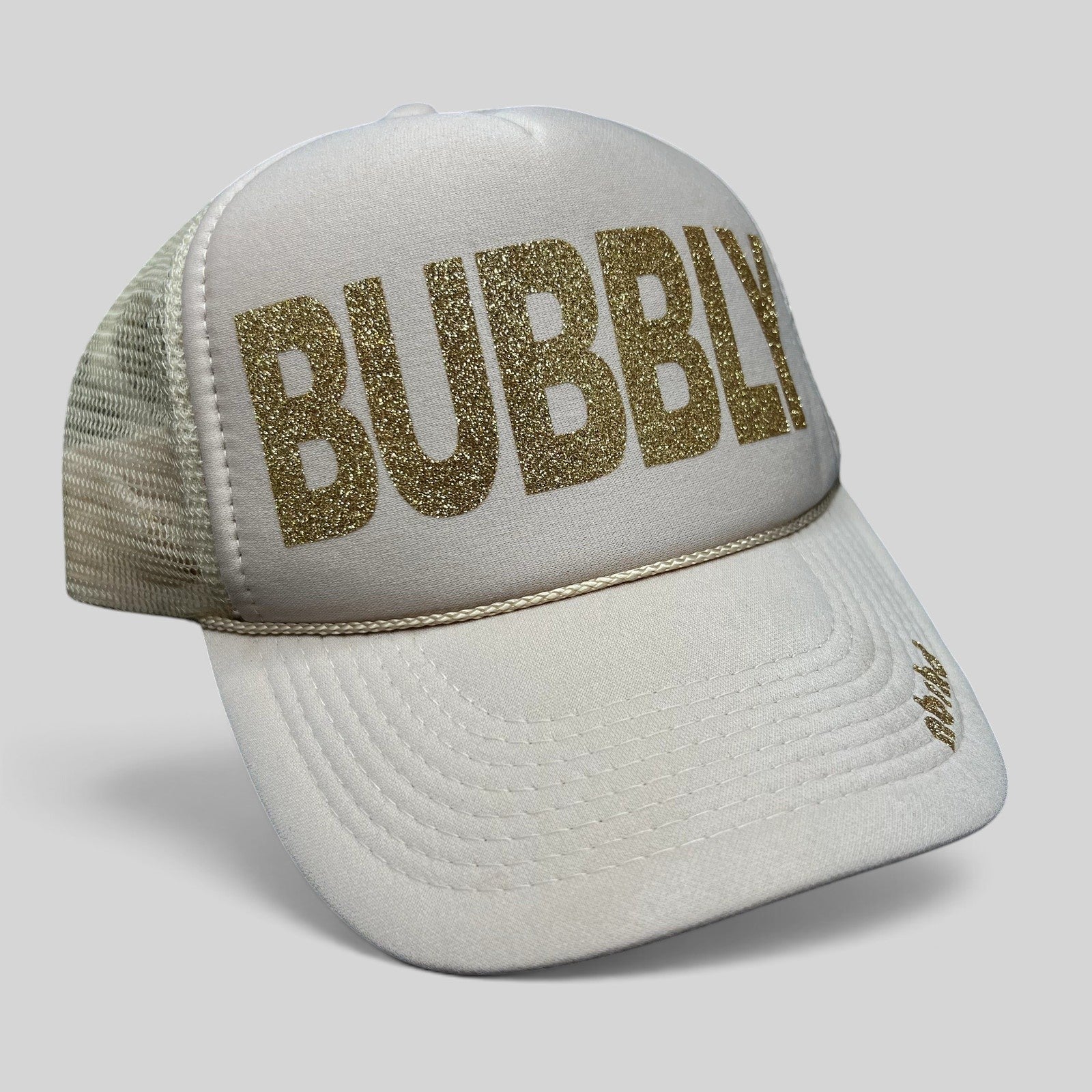 Raree Finds cream trucker hat with gold glitter BUBBLY text and mesh back, featuring NBRHD branding on the visor.