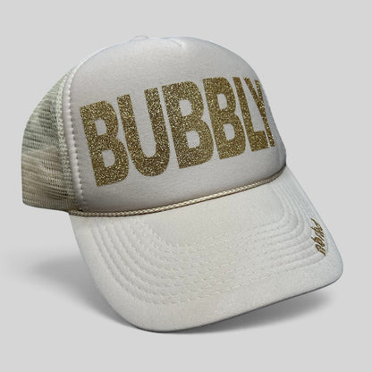 Raree Finds cream trucker hat with gold glitter BUBBLY text and mesh back, featuring NBRHD branding on the visor.