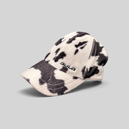 Raree Finds BULA black and white cow print plush fleece baseball cap with curved brim and side logo embroidery.