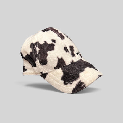 Raree Finds BULA black and white cow print plush fleece baseball cap with a curved brim and side embroidery.