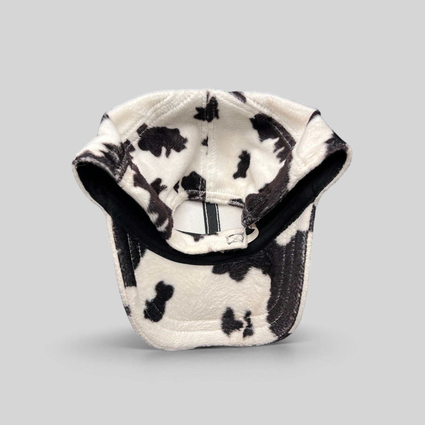 Raree Finds BULA black and white cow print plush fleece cap with an unstructured crown and curved brim