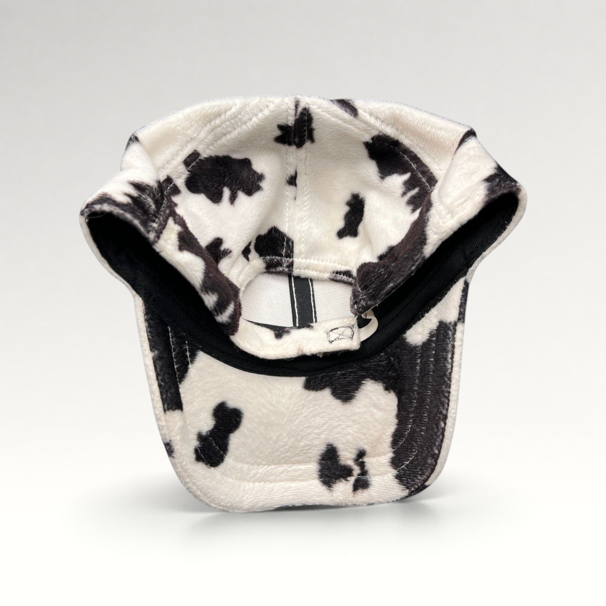 Raree Finds BULA black and white cow print plush fleece cap with an unstructured crown and curved brim