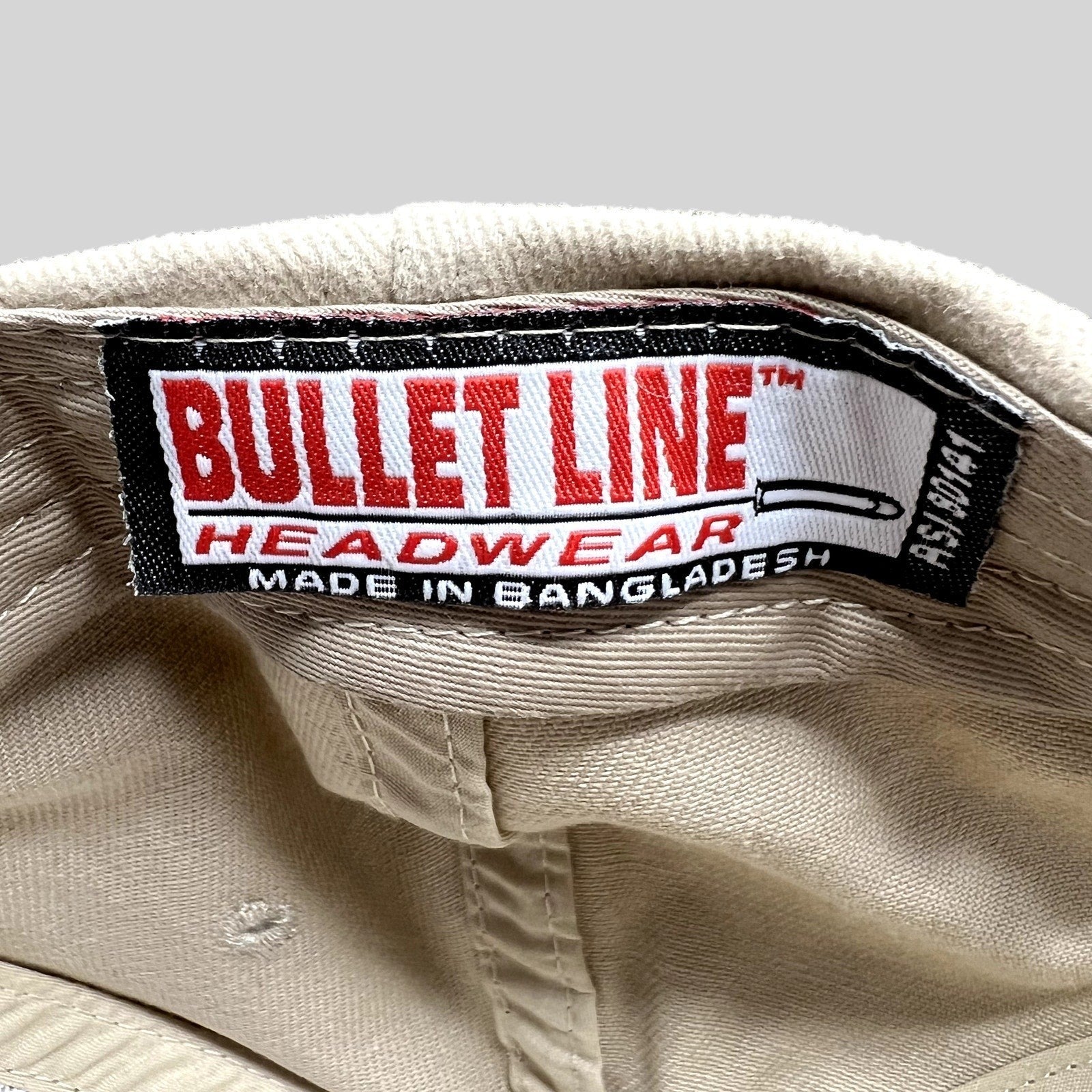 Raree Finds vintage Bullet Line Headwear khaki hat interior tag with red and black branding on a beige fabric crown