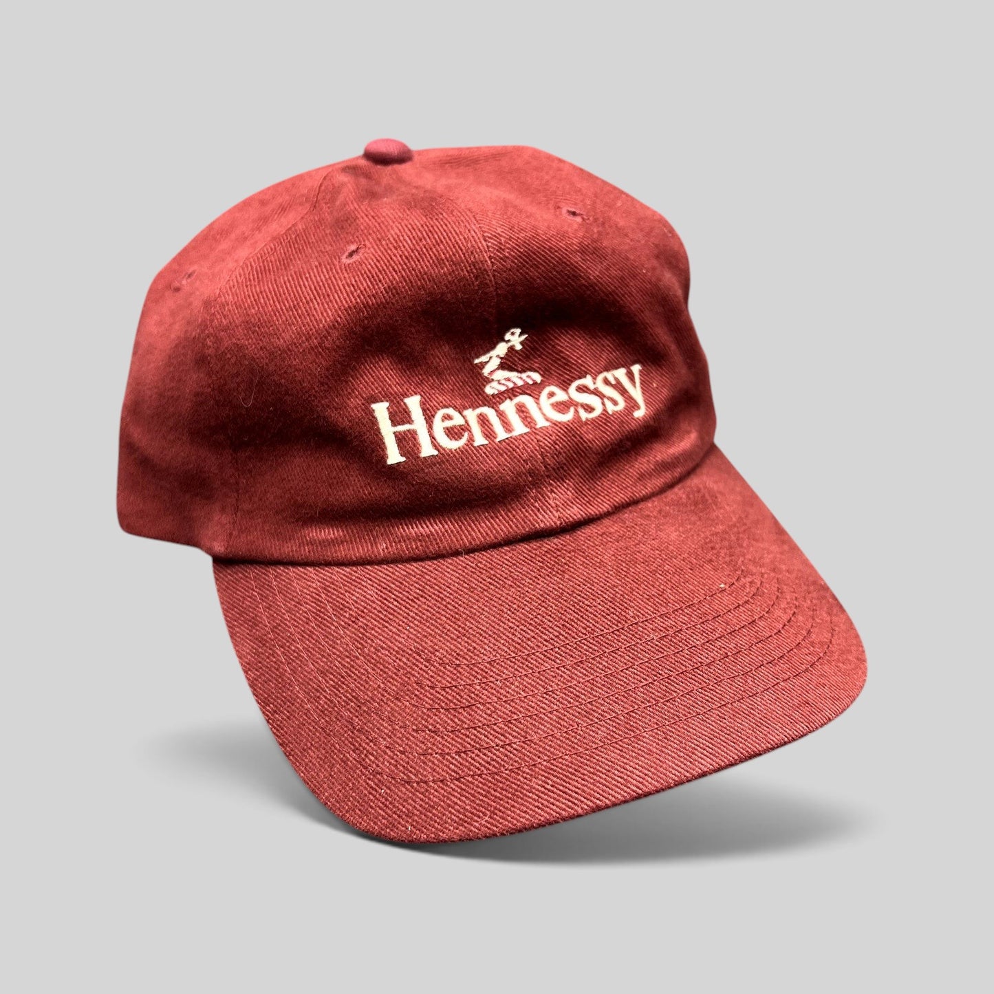 Raree Finds vintage burgundy cotton dad cap with embroidered white Hennessy logo and adjustable brass buckle strapback