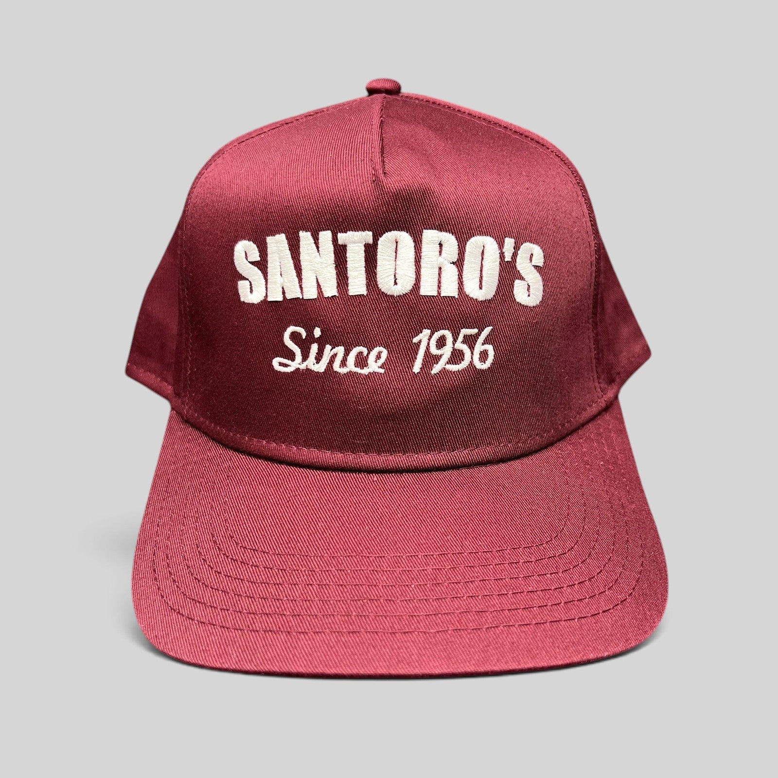 Raree Finds burgundy Otto Cap snapback hat with white Santoro’s Since 1956 embroidery and a structured flat brim.