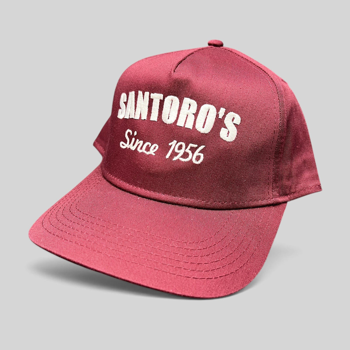 Raree Finds burgundy Otto Cap snapback hat with white Santoro’s Since 1956 embroidery and a structured flat brim.