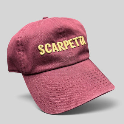 Raree Finds burgundy strapback hat with Scarpetta embroidered in gold on the front, featuring a structured crown.