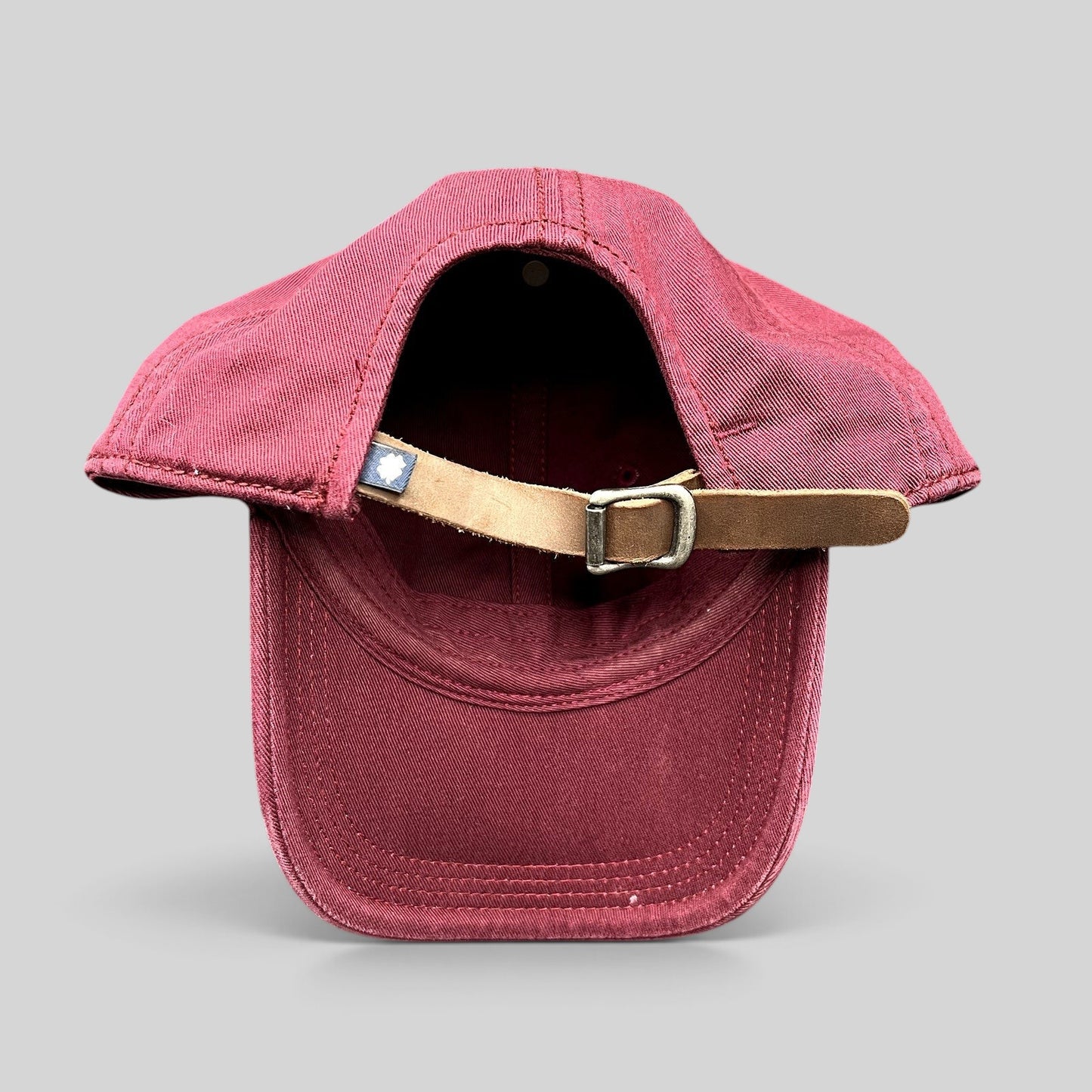Raree Finds Lucky Brand x Budweiser burgundy cotton strapback hat showing the adjustable leather strap and metal buckle