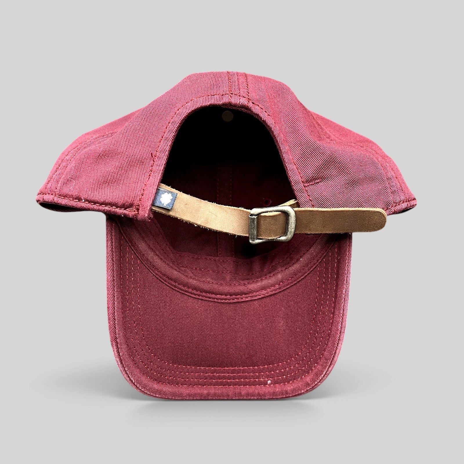 Raree Finds Lucky Brand x Budweiser burgundy cotton strapback hat showing the adjustable leather strap and metal buckle
