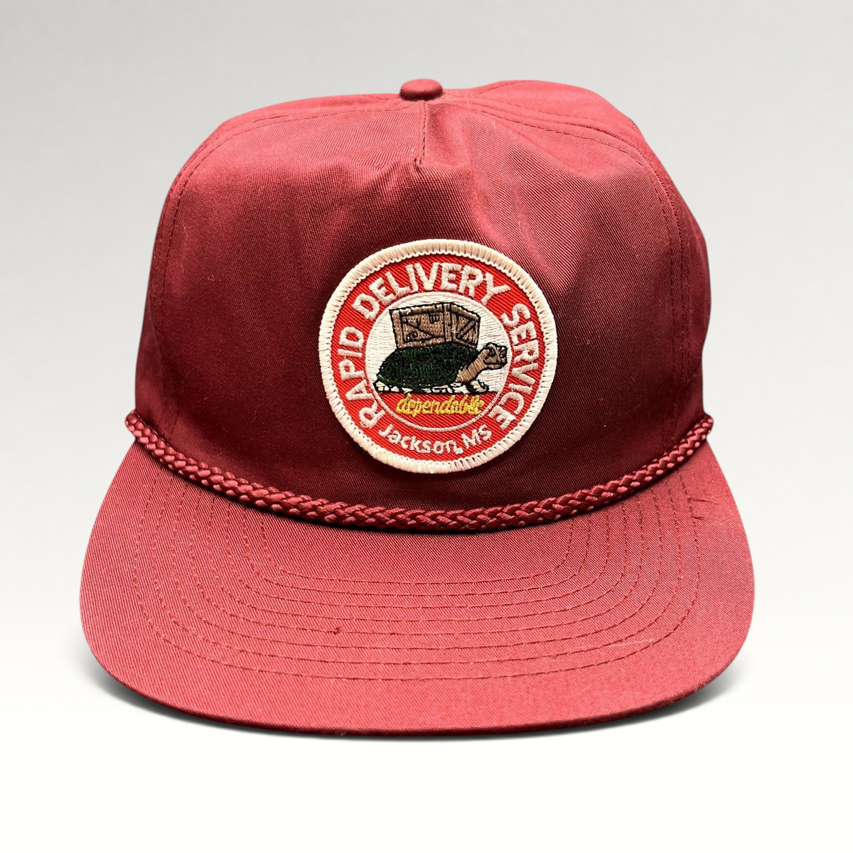 Raree Finds vintage burgundy trucker hat with braided rope brim and Rapid Delivery Service embroidered patch