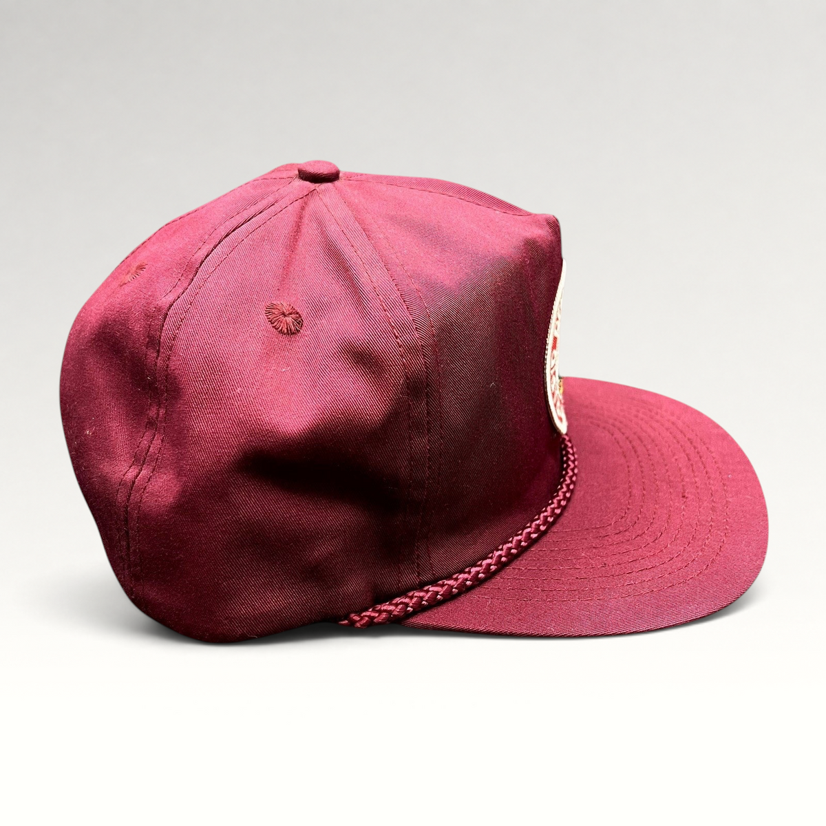 Raree Finds vintage burgundy trucker hat with braided rope detail and Rapid Delivery Service patch