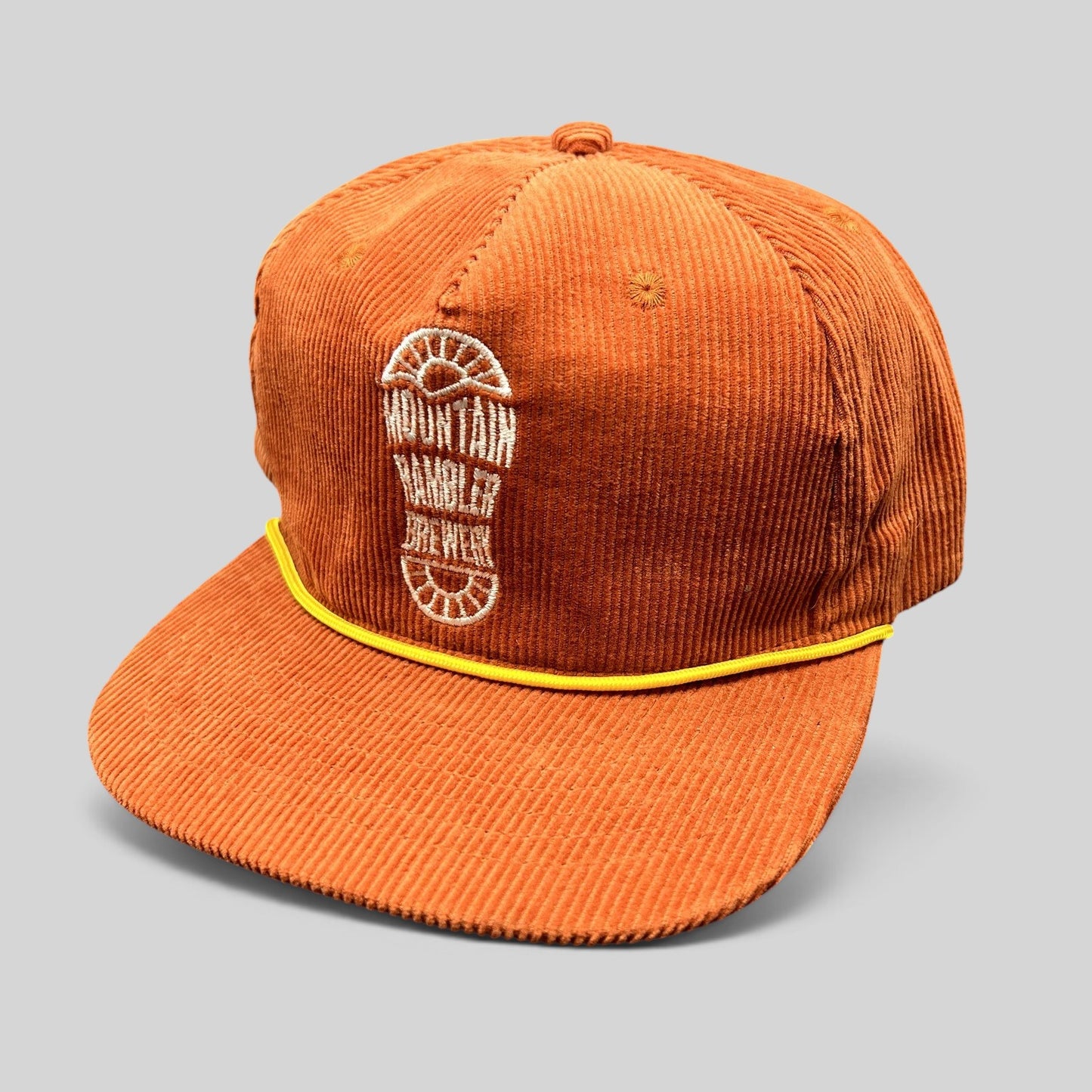 Raree Finds burnt orange corduroy snapback hat with a yellow rope brim accent and Mountain Rambler Brewery logo.