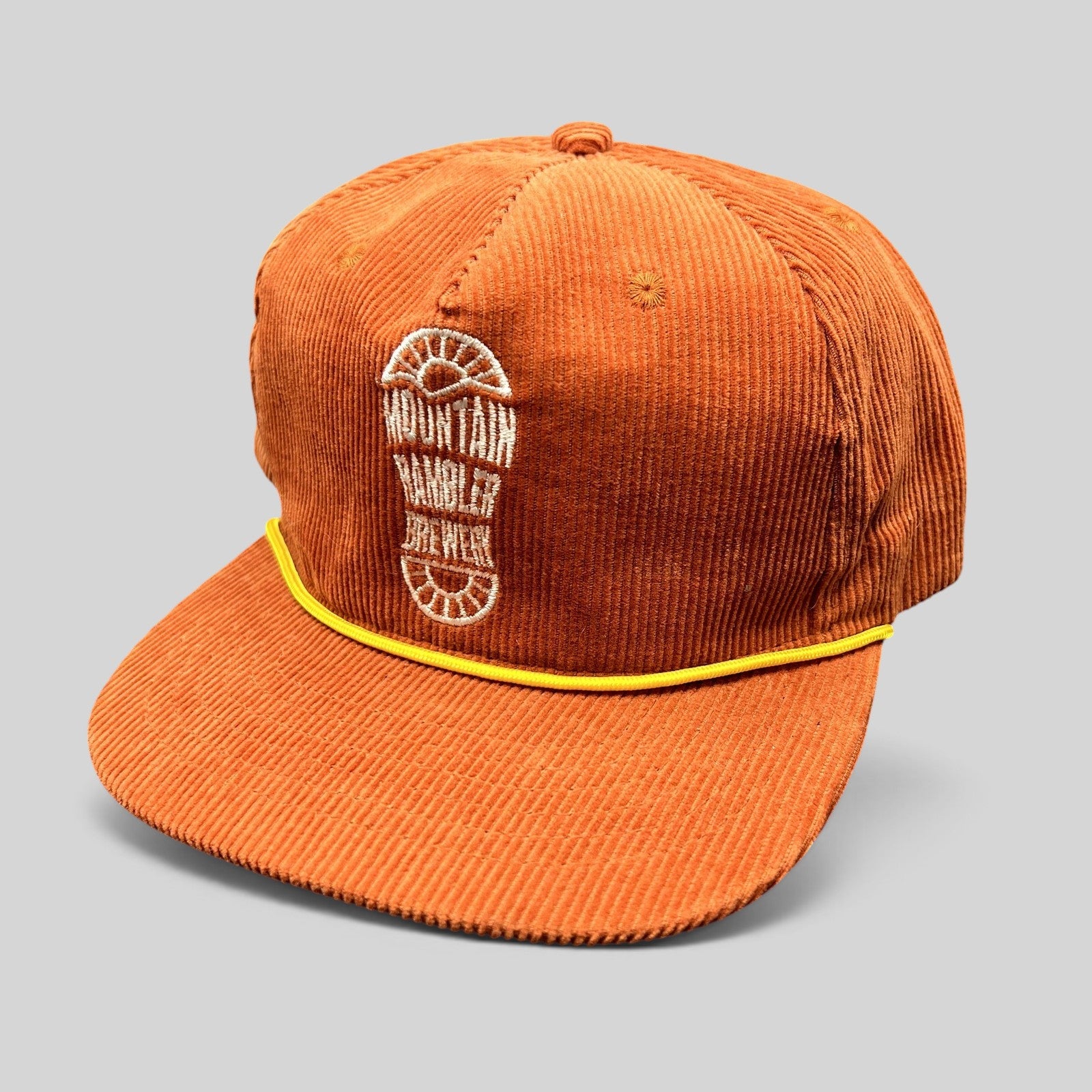 Raree Finds burnt orange corduroy snapback hat with a yellow rope brim accent and Mountain Rambler Brewery logo.