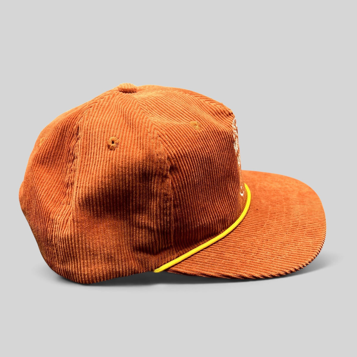 Raree Finds burnt orange corduroy snapback hat with a yellow rope brim accent and retro brewery logo embroidery.