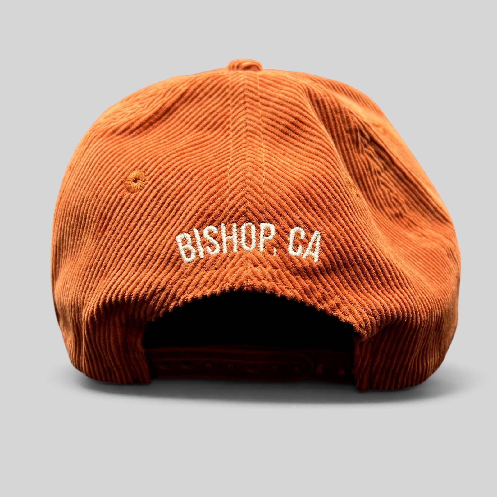 Raree Finds burnt orange corduroy snapback hat with white Bishop CA embroidery on the back and adjustable closure