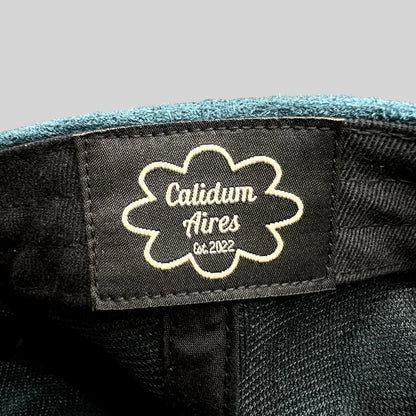 Raree Finds Calidum Aires interior black fabric brand label with white embroidered logo inside a teal suede hat