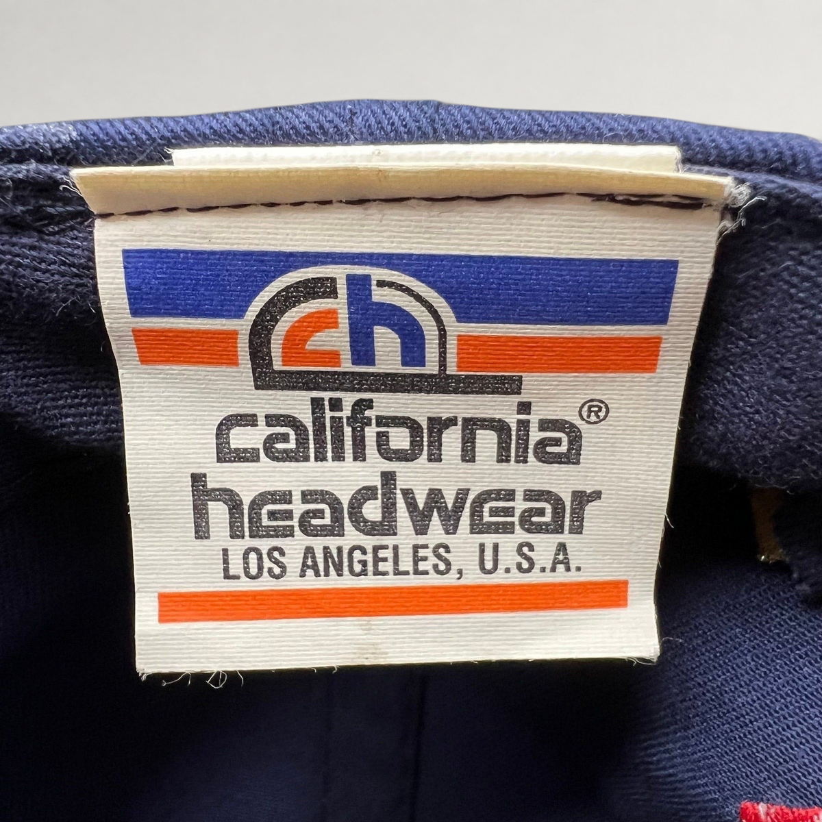 Raree Finds vintage California Headwear clothing tag on a navy blue UCLA 1995 National Champions snapback hat