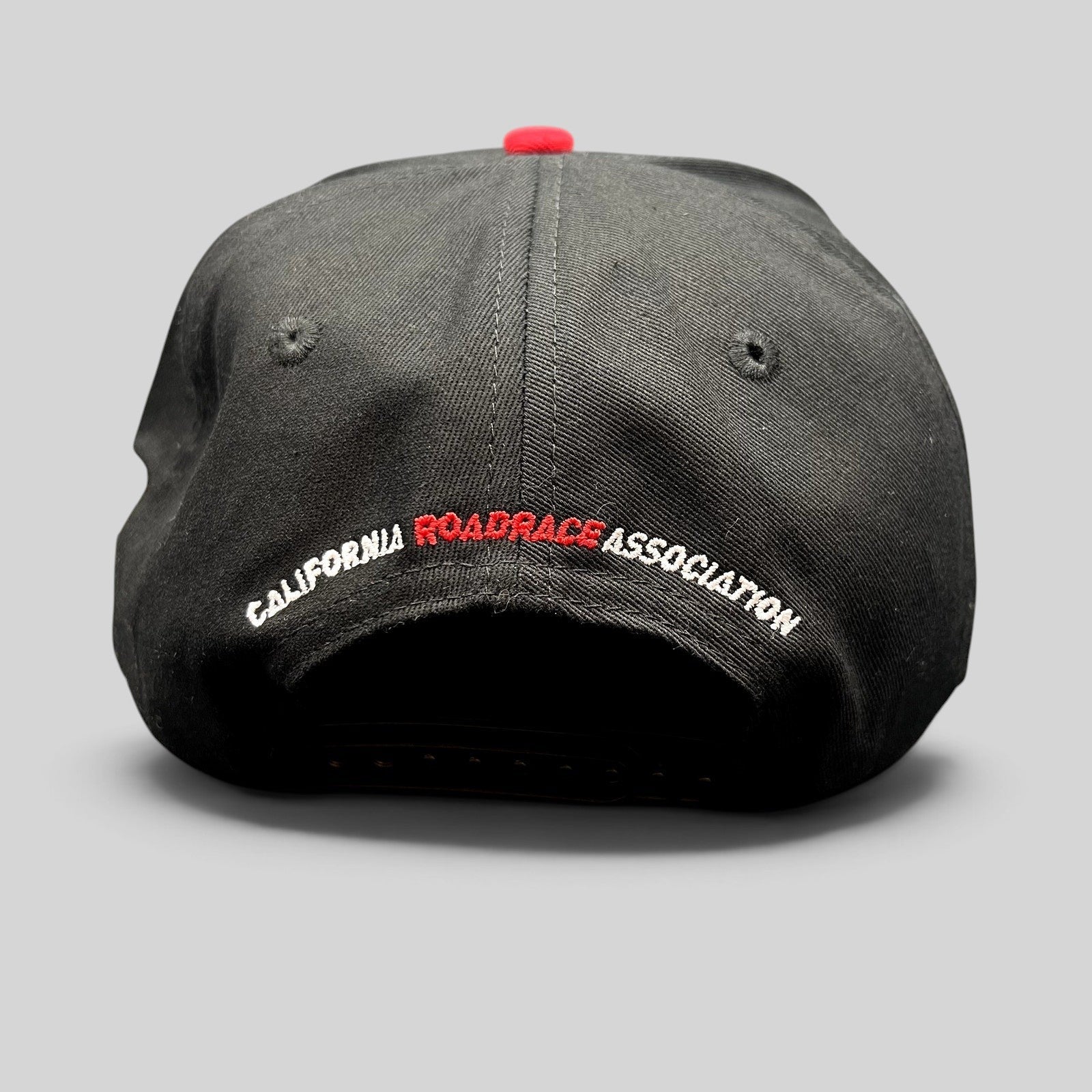 Raree Finds black snapback hat with California RoadRace Association embroidery on the back and a red top button