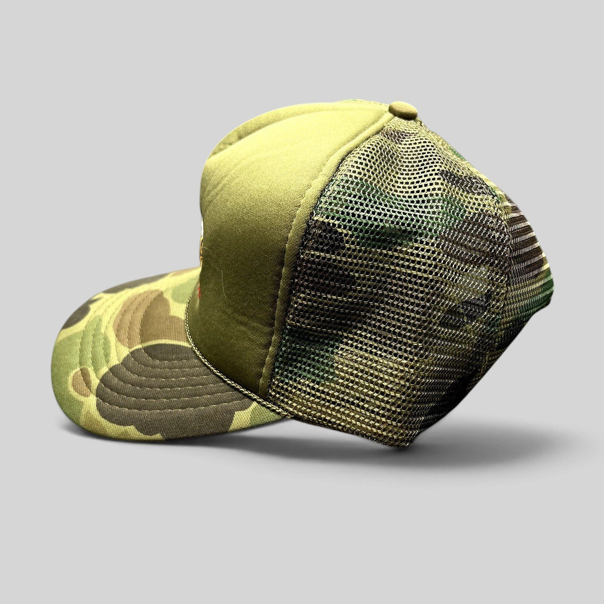 Raree Finds vintage 11th Frame trucker hat with olive foam front, woodland camo brim, and mesh back.