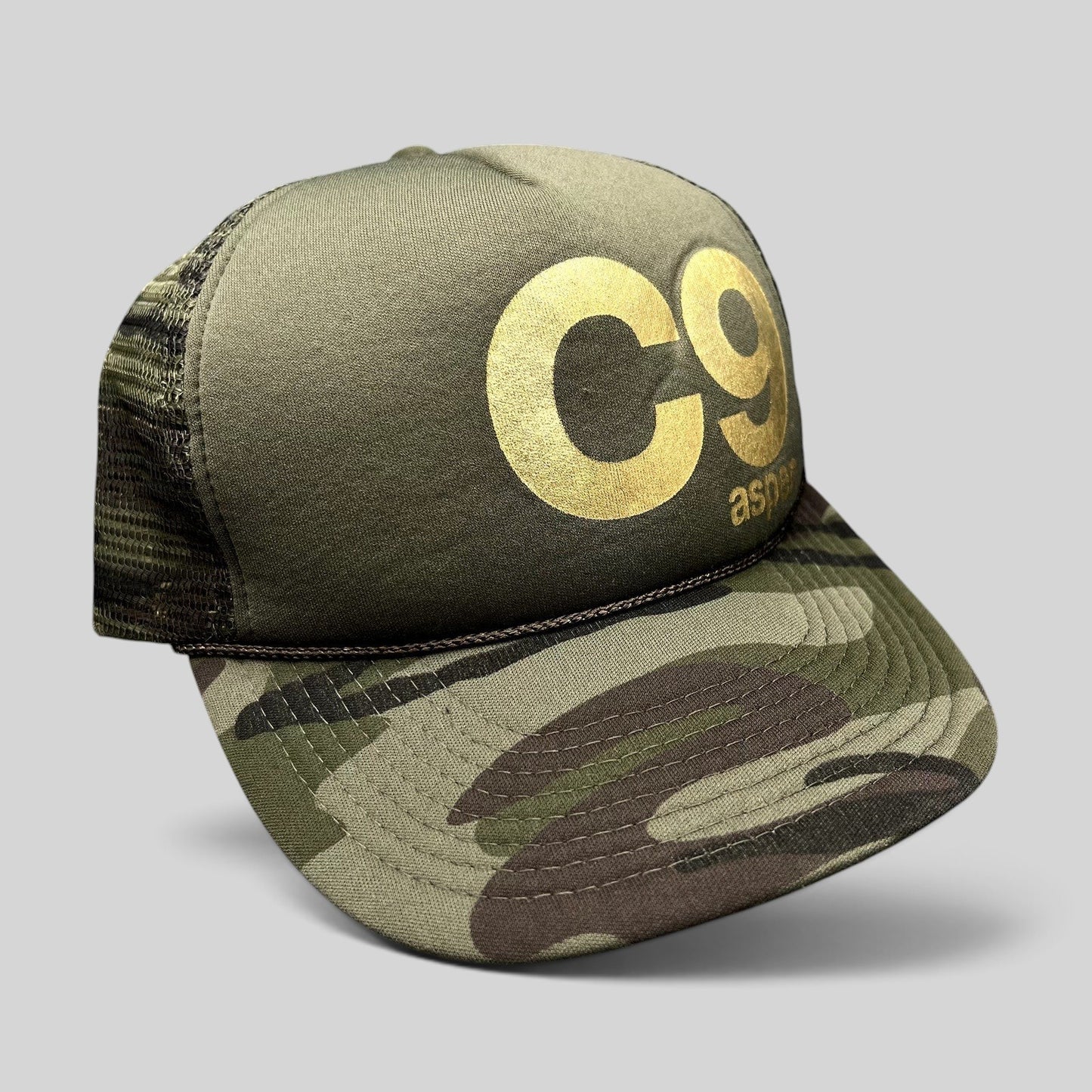 Raree Finds vintage Cloud 9 Aspen trucker hat in olive with camo brim, gold C9 print, and rope detail.