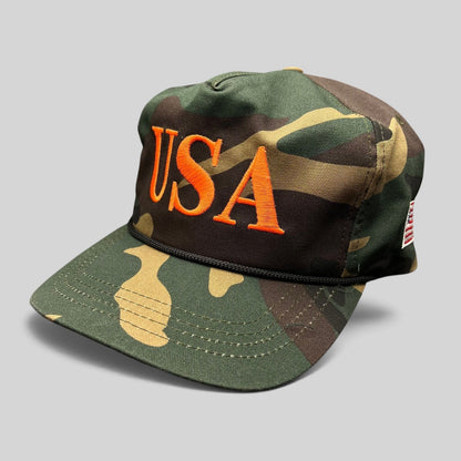 Raree Finds woodland camo snapback hat featuring bold orange USA embroidery and a black rope detail on the brim.