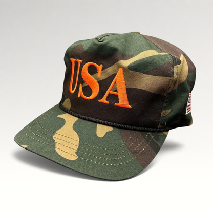 Raree Finds woodland camo snapback hat featuring bold orange USA embroidery and a black rope detail on the brim.