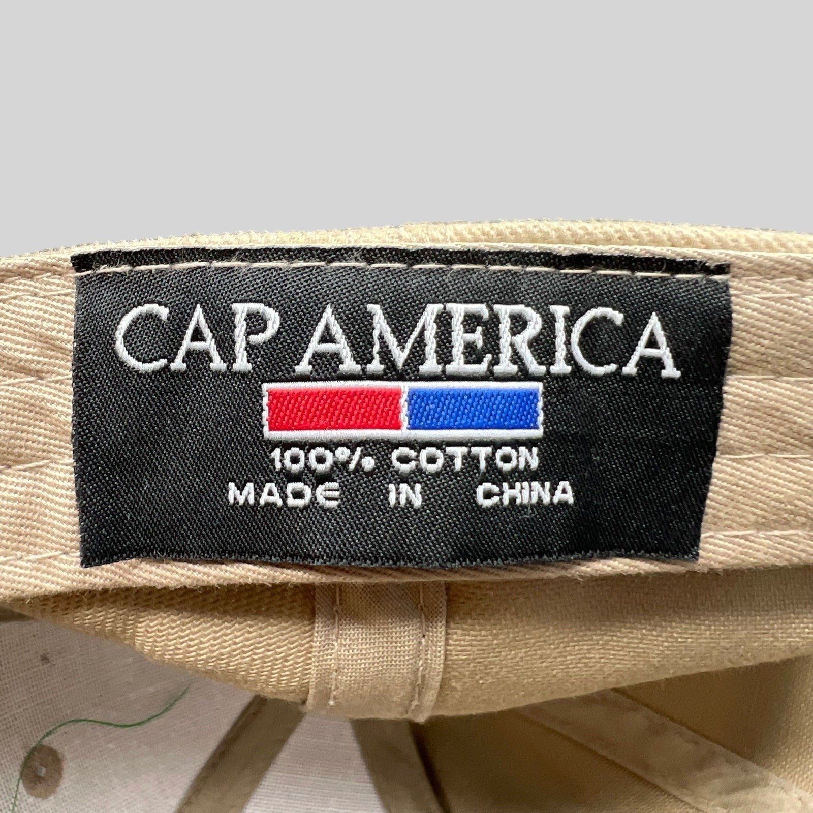 Raree Finds vintage Cap America hat interior label showing 100 percent cotton material and brand logo on beige fabric