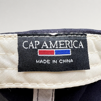 Raree Finds Cap America interior woven brand label featuring white text on a black background inside a navy hat