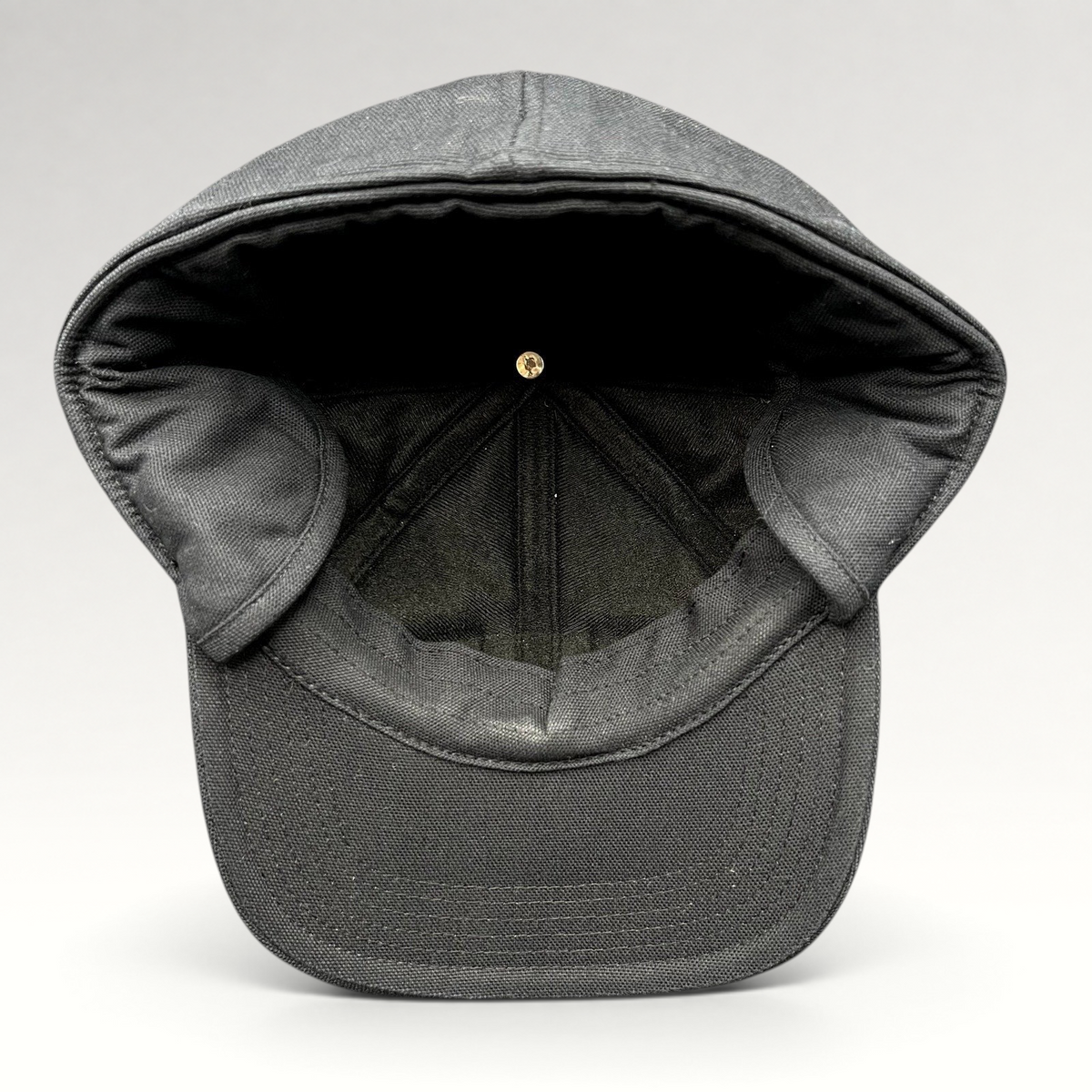 Raree Finds black Carhartt duck canvas workwear cap with fold-down ear warmers shown from the interior view.