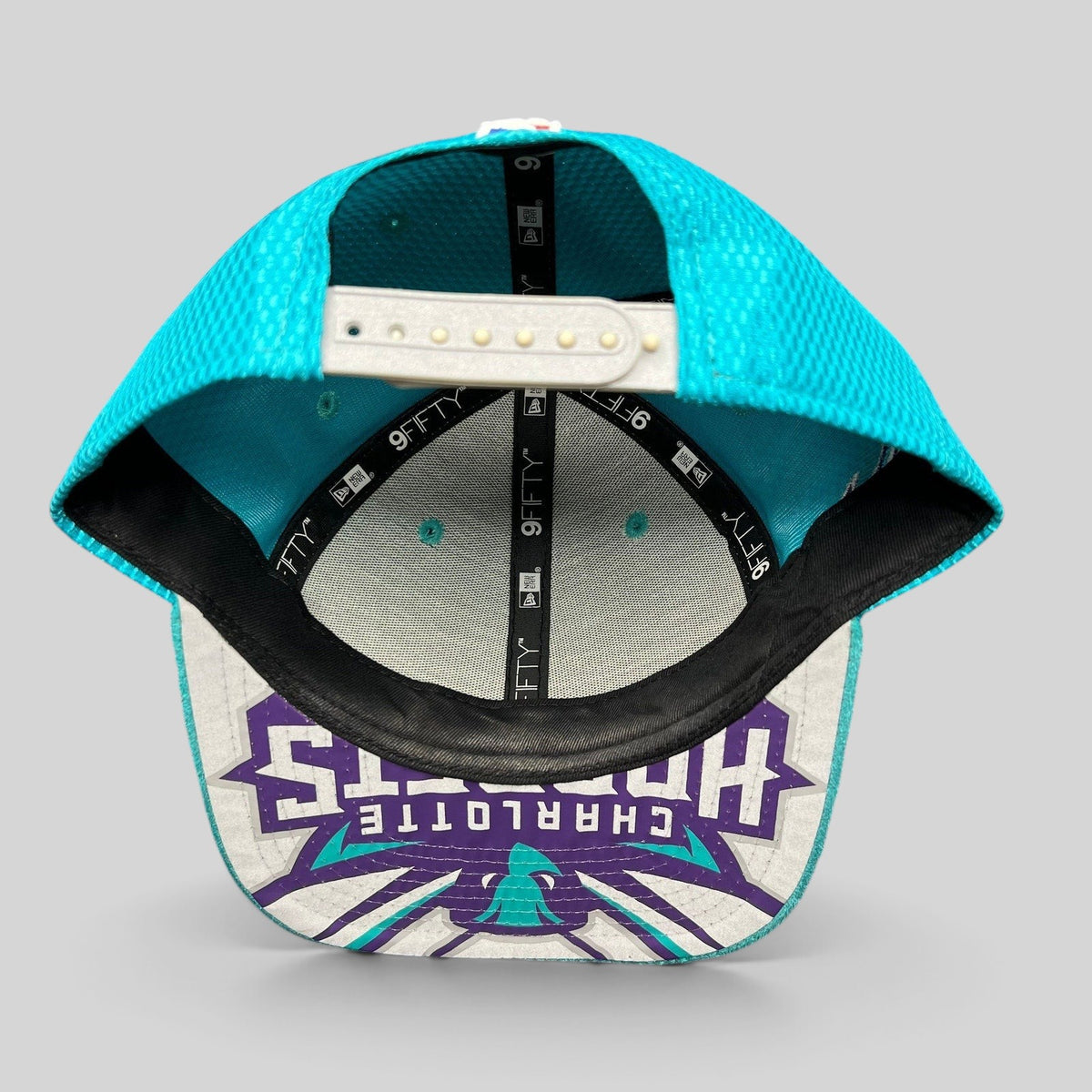 Raree Finds Charlotte Hornets New Era 9FIFTY snapback hat showing the interior teal performance fabric and brim logo