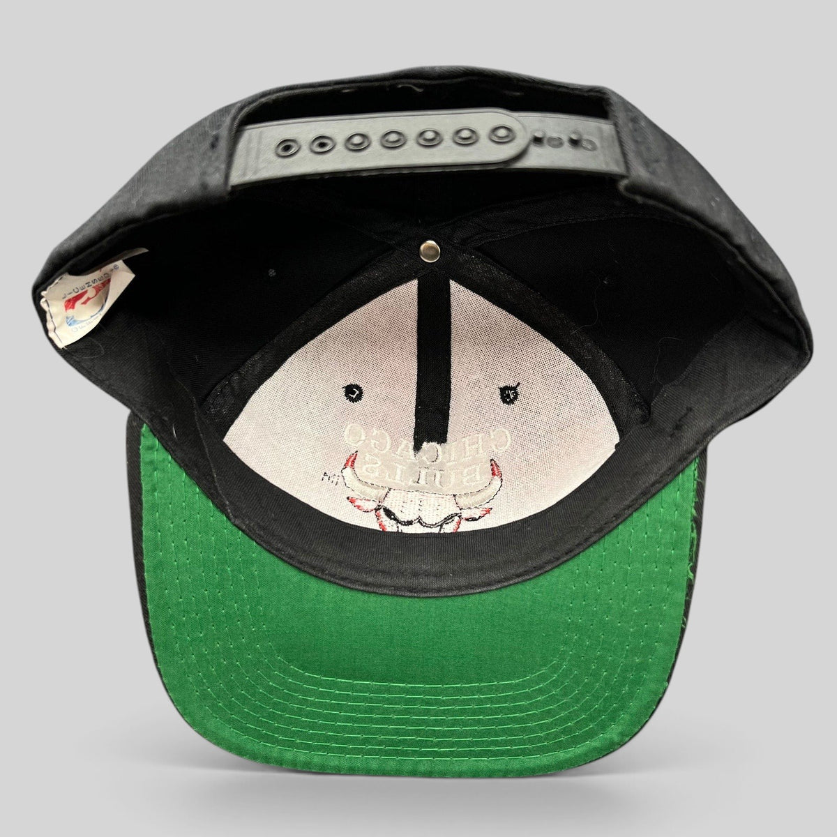Raree Finds vintage 90s Chicago Bulls AJD snapback hat interior view showing green undervisor and black snap closure