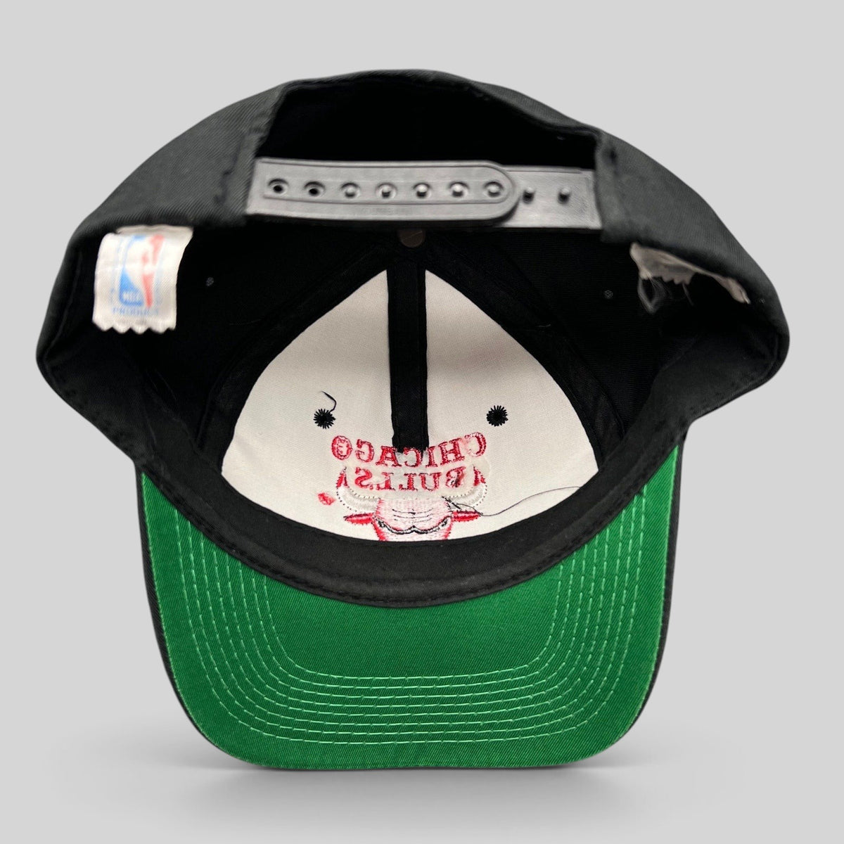 Raree Finds vintage 90s Chicago Bulls snapback hat with black crown, green under-visor, and interior NBA logo tag.