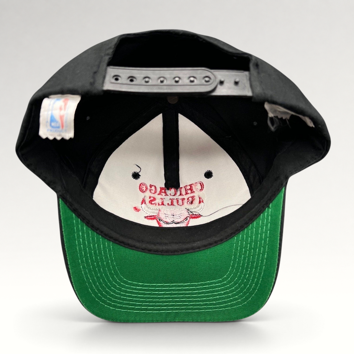 Raree Finds vintage 90s Chicago Bulls snapback hat with black crown, green under-visor, and interior NBA logo tag.