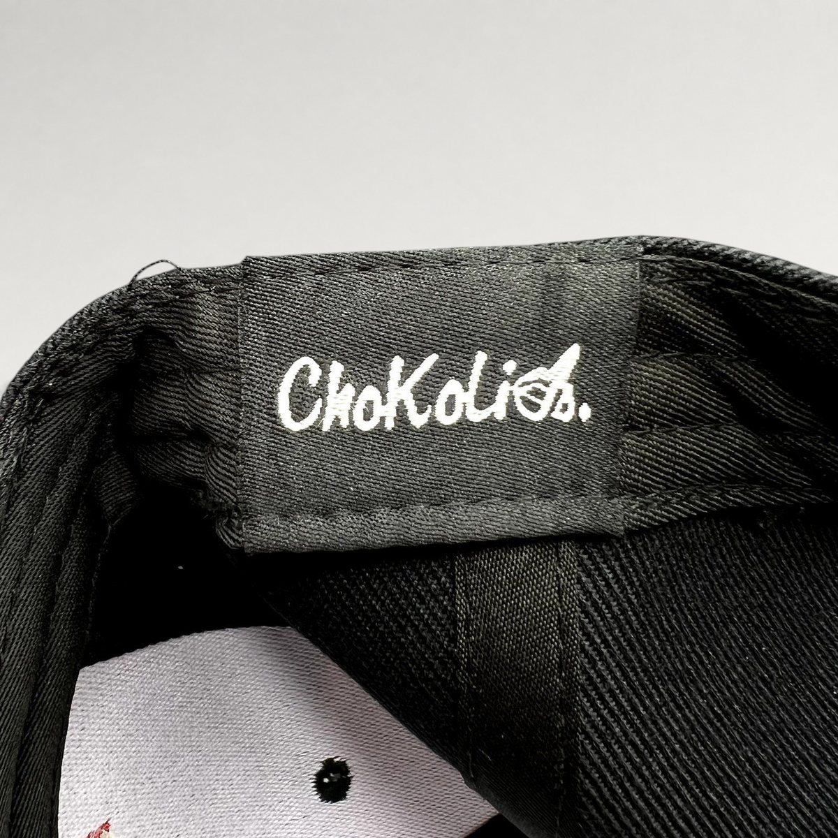 Raree Finds black Chokolids snapback hat interior label detail showing white embroidered brand logo