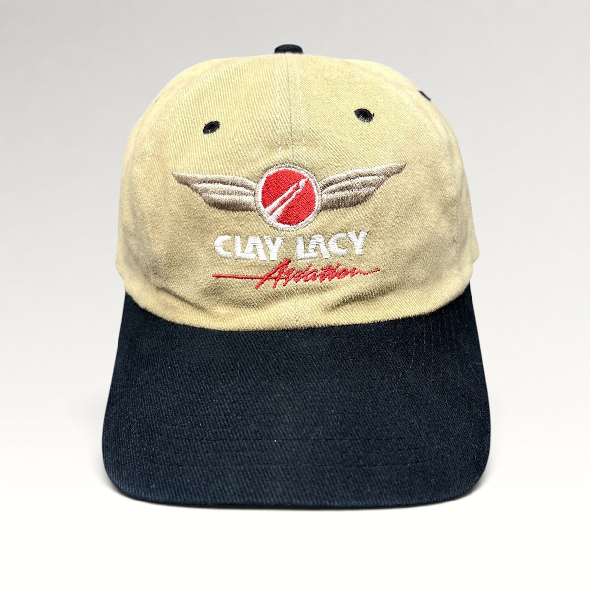 Raree Finds vintage Clay Lacy Aviation cotton twill strapback cap with tan crown, black brim, and winged logo.