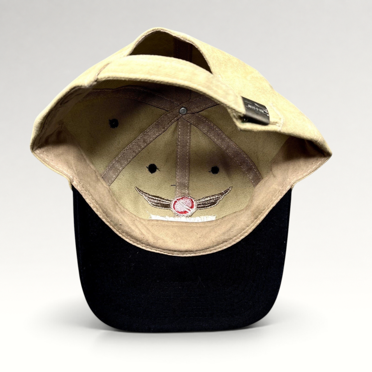 Raree Finds vintage Clay Lacy Aviation strapback cap with tan cotton crown, black brim, and interior winged logo.