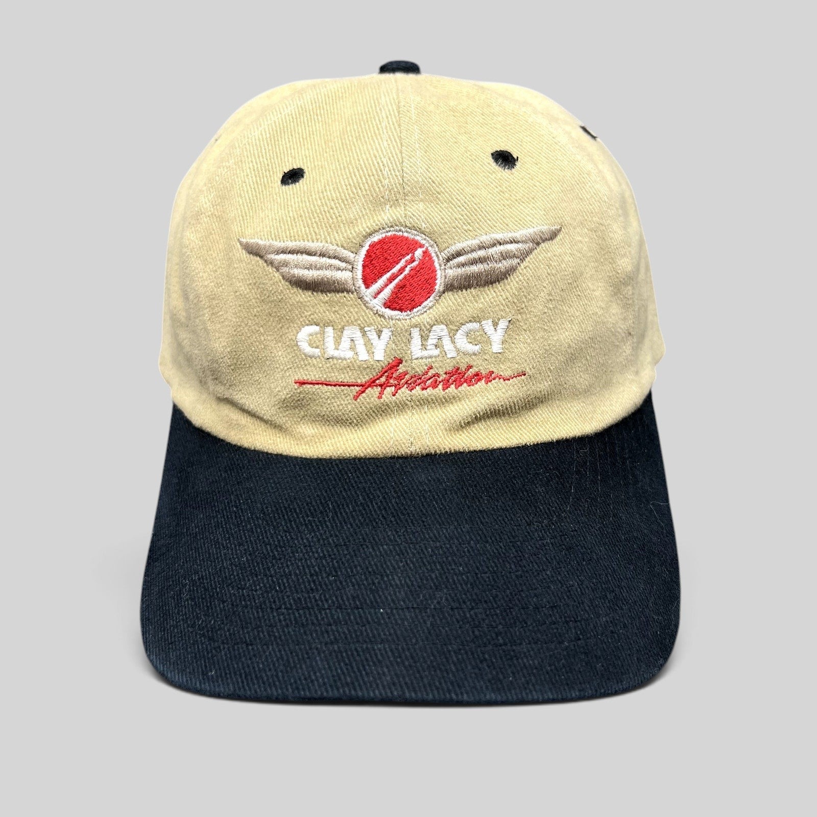 Raree Finds vintage Clay Lacy Aviation strapback hat with tan cotton crown, black brim, and embroidered logo.