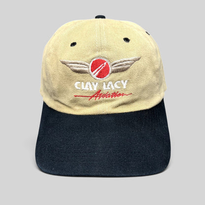 Raree Finds vintage Clay Lacy Aviation strapback hat with tan cotton crown, black brim, and embroidered logo.
